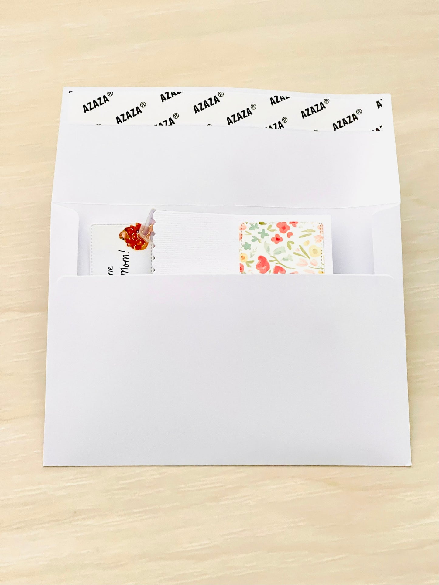 White envelope with Mother's Day pop-up card on a beige surface