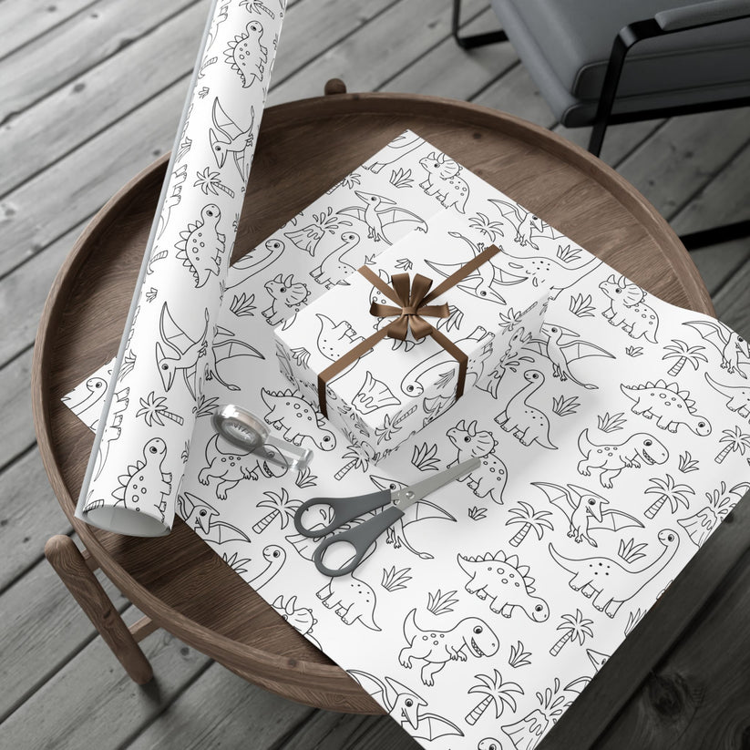Dinosaur patterned gift wrap with scissors on a wooden table
