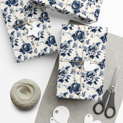 Gift boxes wrapped in blue floral paper with scissors and yarn on a white surface
