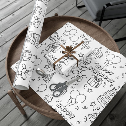 Roll of birthday-themed wrapping paper on a wooden table with a gift box.