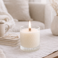 Candle burning on a table with a cozy living room background