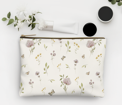 Floral-patterned pouch with cosmetic items on a light background
