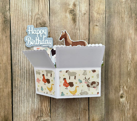 Card with animal illustrations and a horse on top, against a wooden background