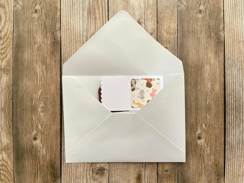 White envelope with a floral card on a wooden surface