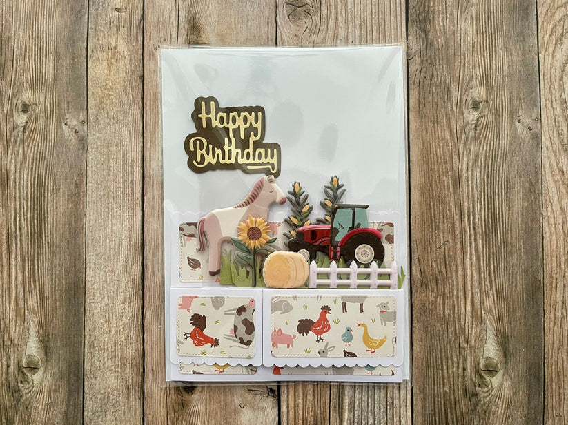 Birthday card with farm-themed illustrations on a wooden surface