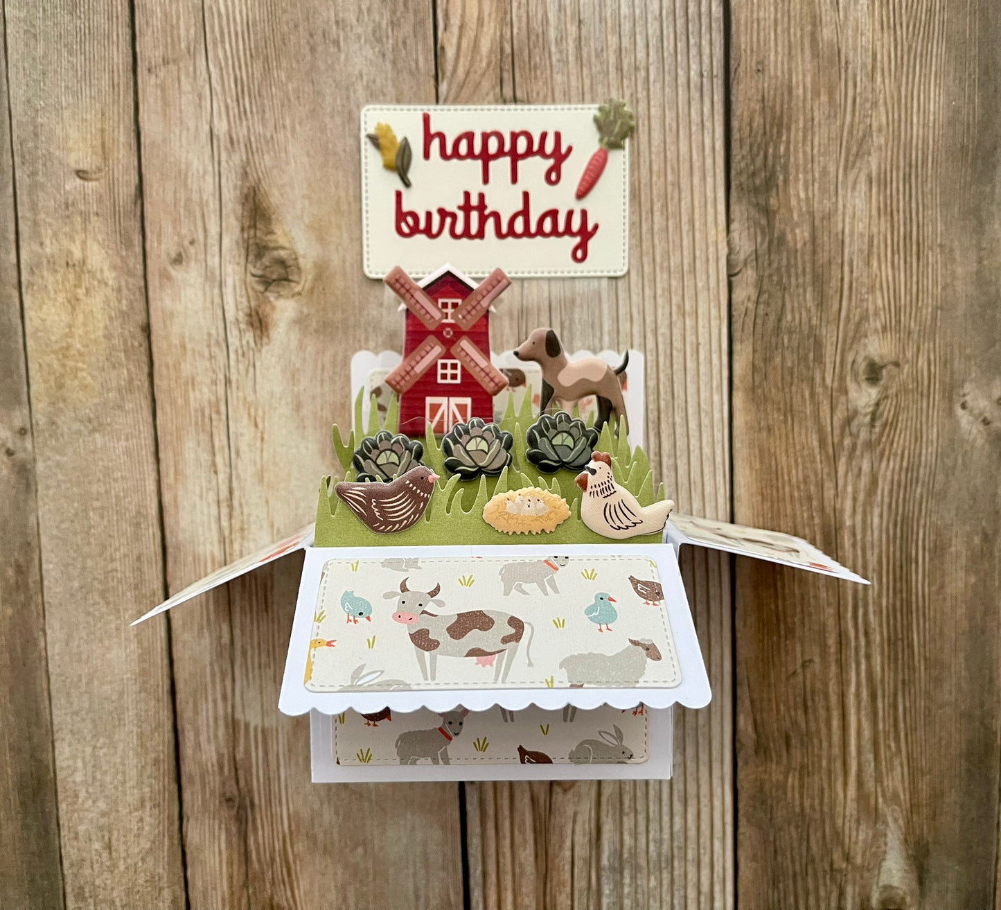 Pop-up birthday card with farm animals and windmill design on a wooden background