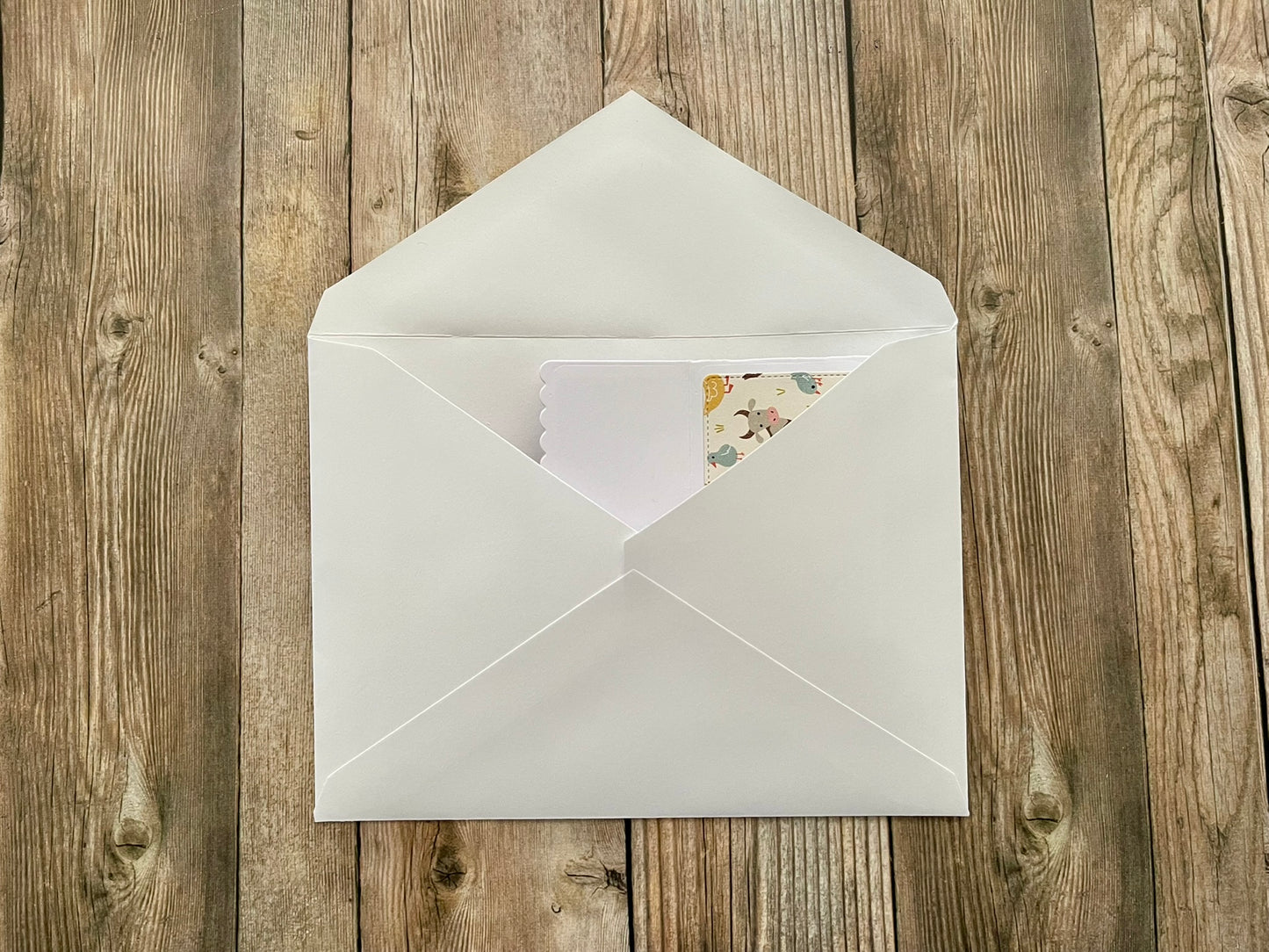 White envelope with a card on a wooden surface