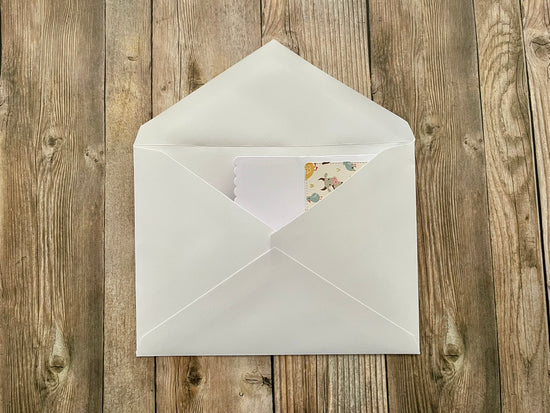 White envelope with a card on a wooden surface