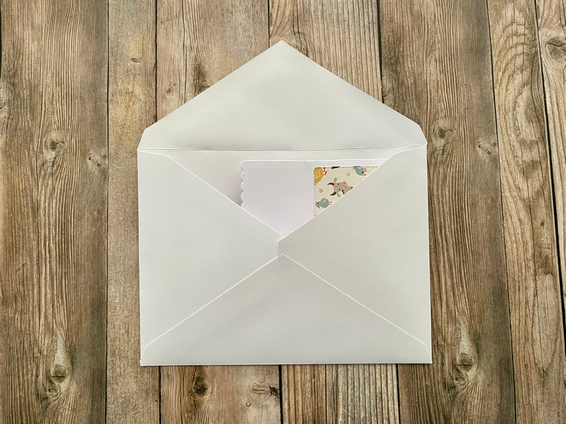 White envelope with a card on a wooden surface