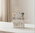 Pop-up birthday card with floral design and vintage masks on a wooden table.