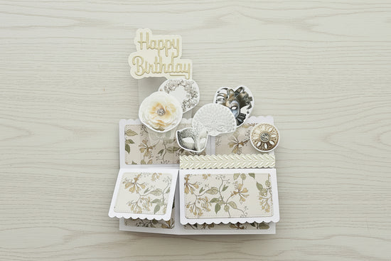 Folded flat  pop-up birthday card with floral designs and 'Happy Birthday' text on a black marble background
