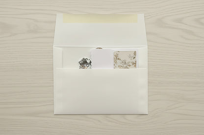 White envelope with a matching card on a textured beige surface