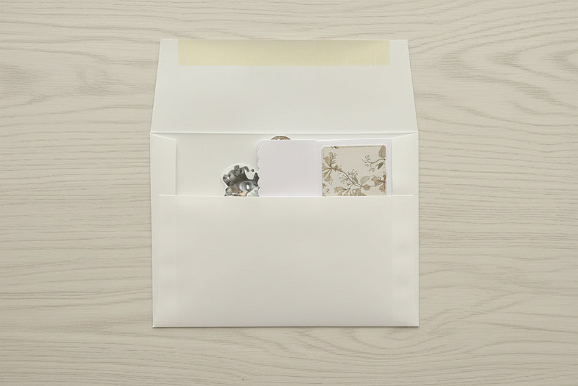 White envelope with a matching card on a textured beige surface