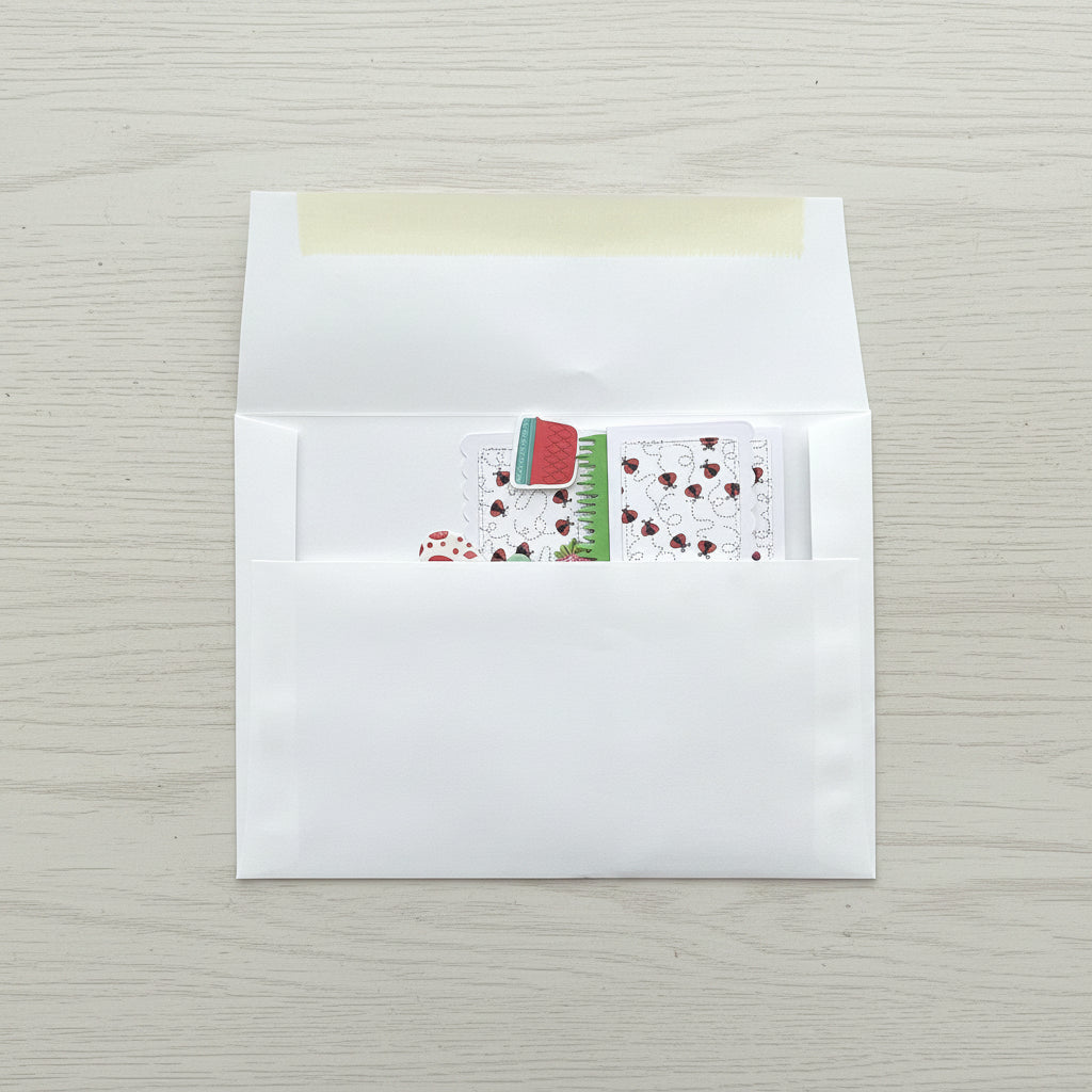 White envelope with a small card featuring a red flower design on a black marble surface