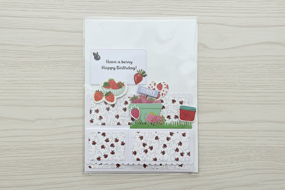 Card with strawberry-themed design on a black marble background