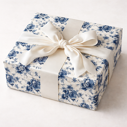 Gift box wrapped in blue floral paper with a white ribbon on a white background
