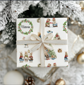 Gift box under a Christmas tree with festive, watercolor, hand illustrated images of woodland animals dressed for Christmas in Victorian outfits.  A wreath surrounds personalization of "Victoria".