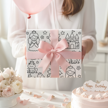Gift box with pink ribbon and princess themed illustrations held by a person, with a cake and balloons in the background.