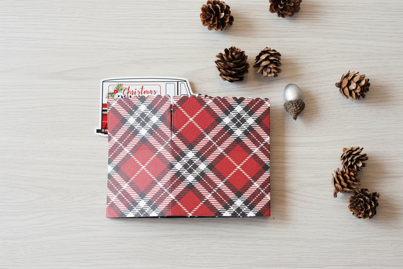 Box style pop-up card folded.  Red, black and white plaid pattern on the background.
