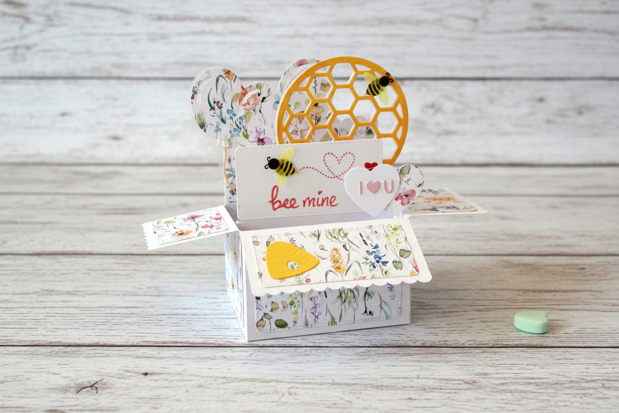 Pop-up Valentine's Day card with honeycomb design and heart-shaped elements on a wooden surface.