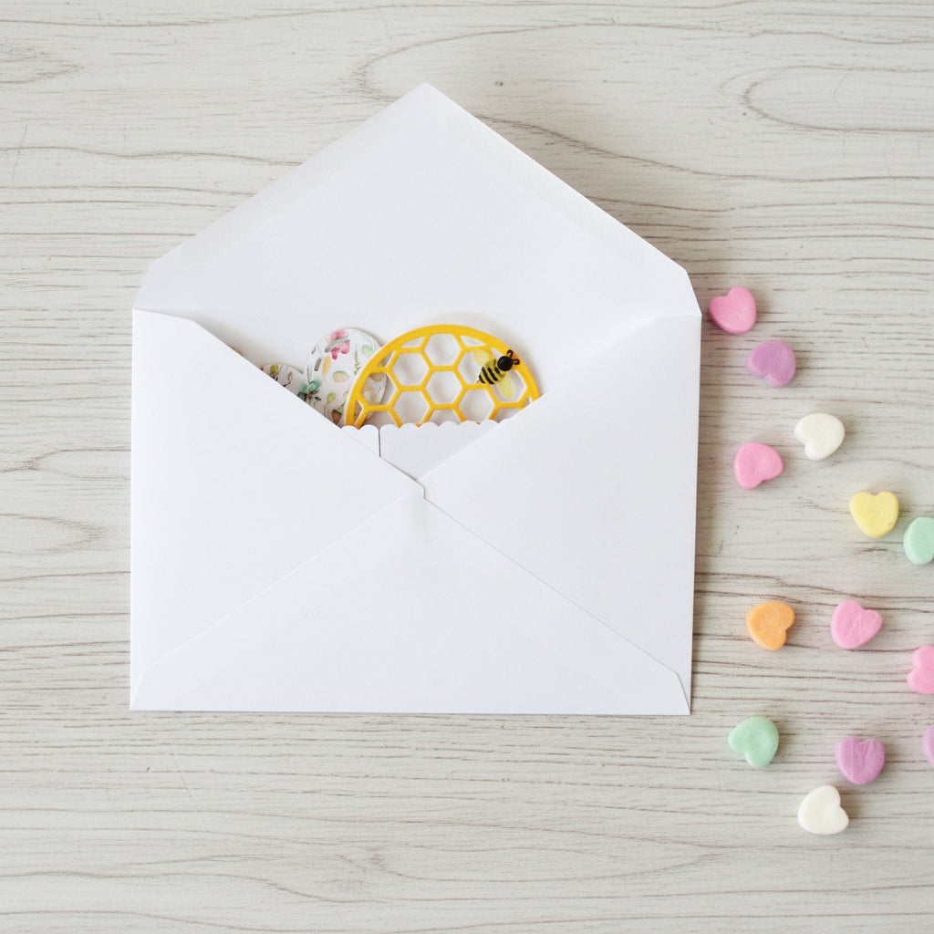 White envelope with a folded pop-up Valentine's Day card inside.