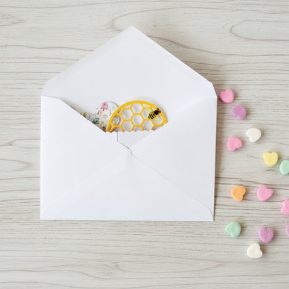 White envelope with a folded pop-up Valentine's Day card inside.