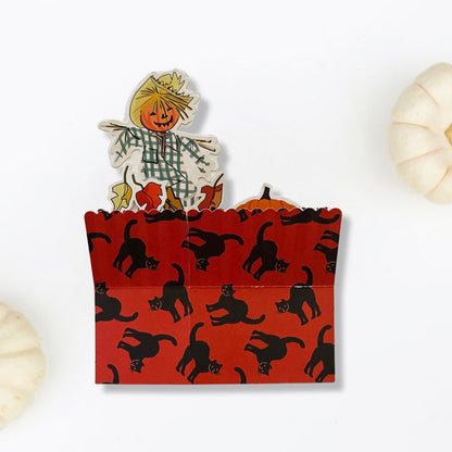 Halloween-themed paper bag with a scarecrow decoration on a white background