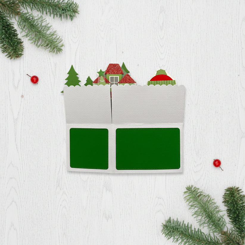 Christmas-themed box style po-up card with small trees and a house on a white background
