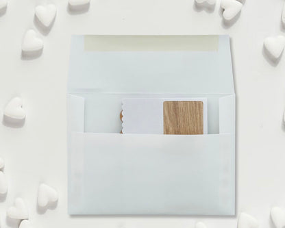 White envelope with a wooden card inside on a white background