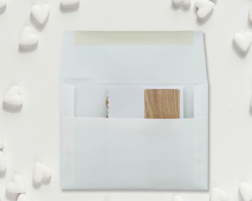 White envelope with a wooden card inside on a white background