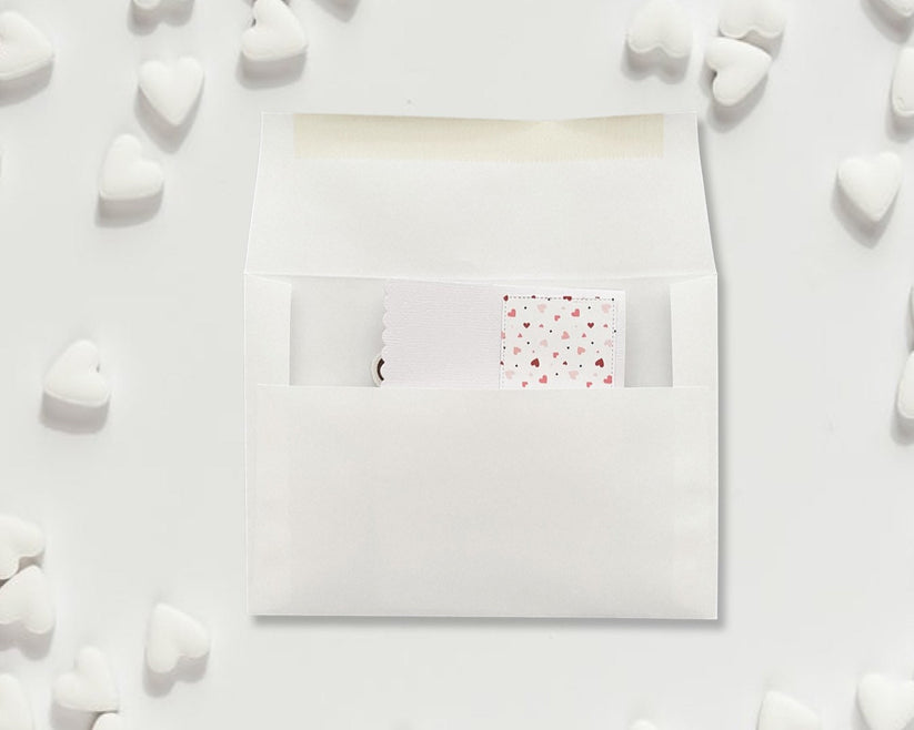 White envelope with a pink heart pattern on a white background with heart shapes