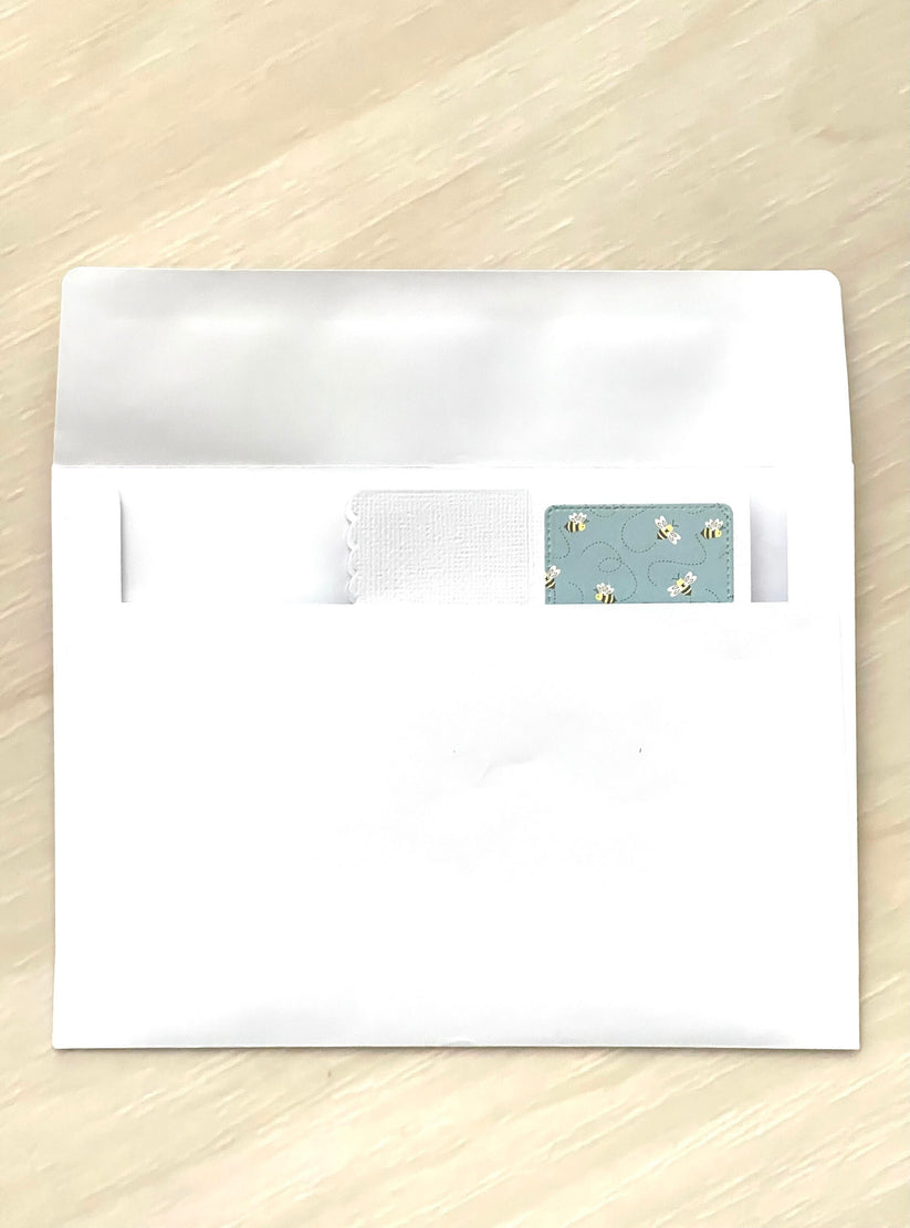 White envelope with a decorative flap on a wooden surface