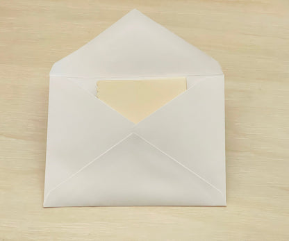 White envelope with a beige interior on a wooden surface
