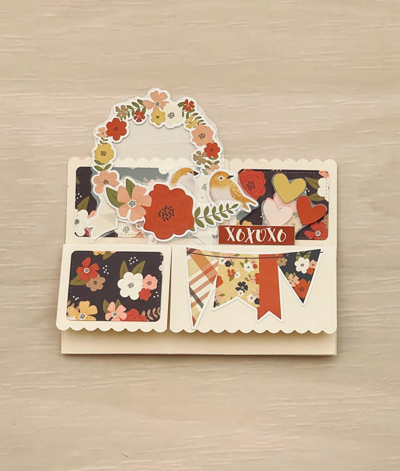 Decorative card with floral and nature-themed designs on a wooden surface