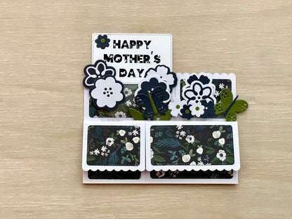 Card with 'Happy Mother's Day' text and floral designs on a wooden surface