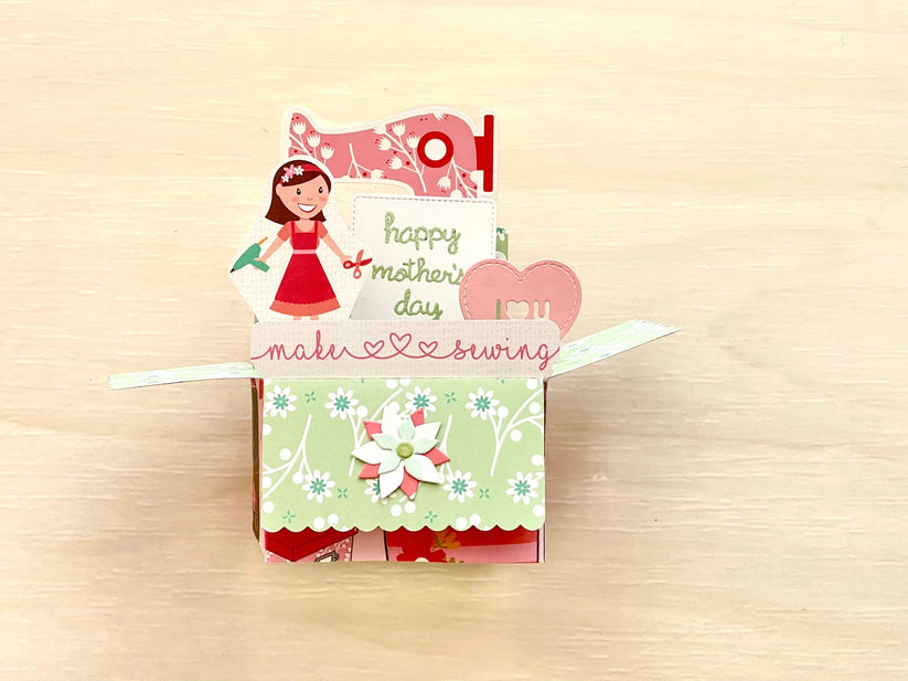 Pop-up card with a mother and her crafting tools design on a beige background