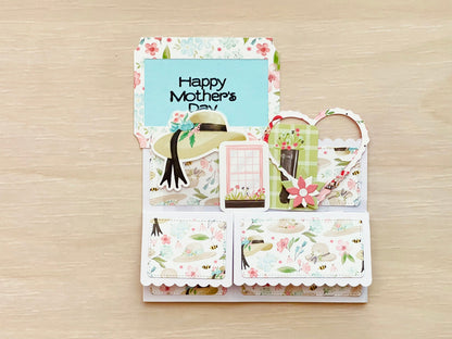 Mother's Day pop-up card with floral designs folded flat  on a wooden surface