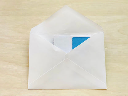 White envelope with a blue card on a wooden surface