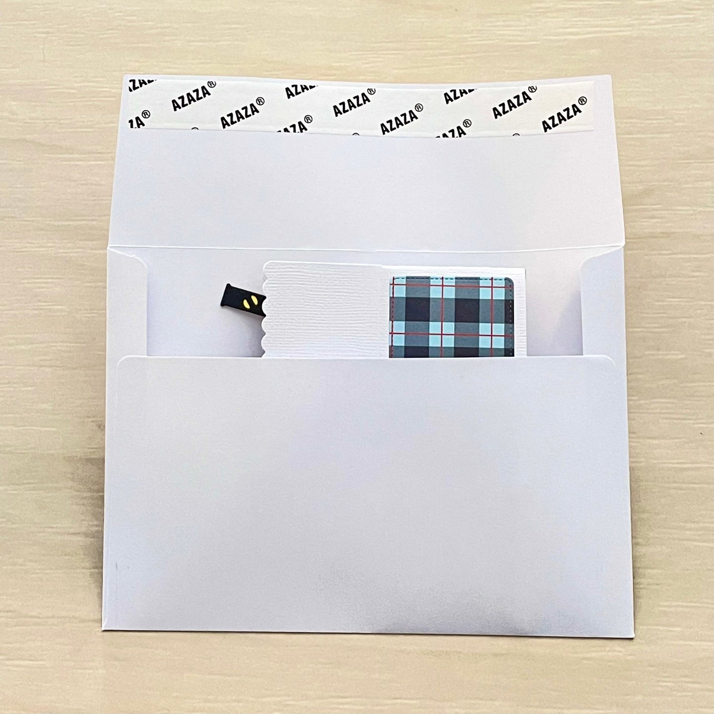 White envelope holding blue plaid and white Father's Day pop-up card