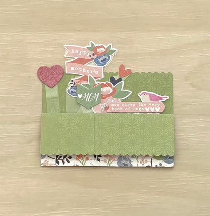 Decorative card with 'Happy Mother's Day' text on a wooden surface