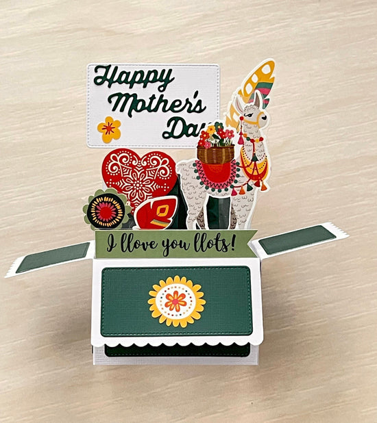Pop-up card with llama and floral elements on a wooden surface