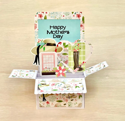 Open Mother's Day pop-up card with floral design and 'Happy Mother's Day' text on a wooden surface.