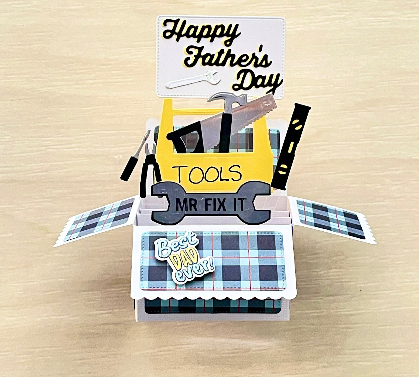 Pop-up Father's Day card with toolbox design on a wooden surface