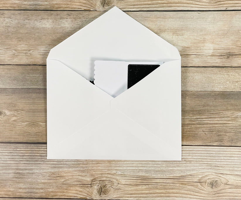 White envelope with a card on a wooden surface