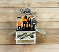 Halloween-themed box pop-up card a skeleton and Frankenstein monster, scary haunted house and cemetery. Message of Happy Halloween and spooky fun on a wooden surface