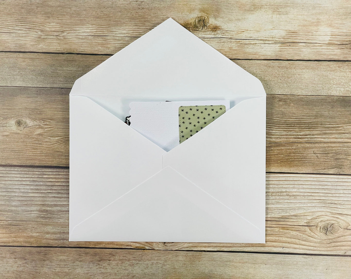 White envelope with a card on a wooden surface