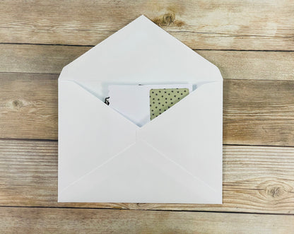 White envelope with a card on a wooden surface