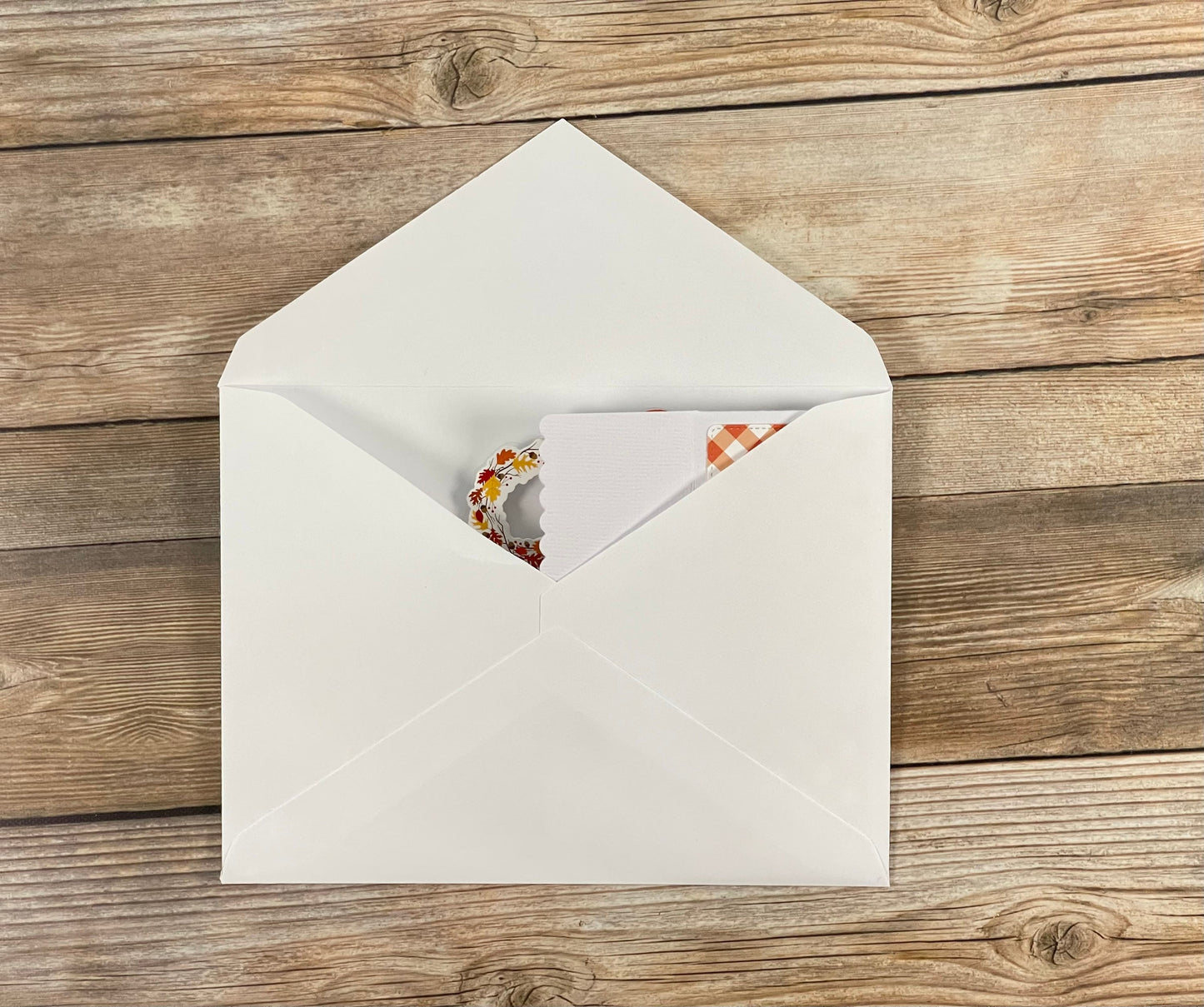 White envelope with a card on a wooden surface