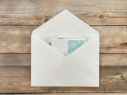 White envelope with a card inside on a wooden surface