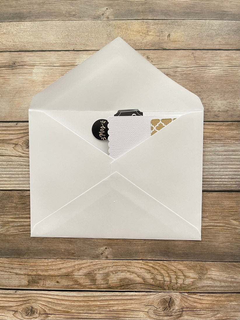 White envelope with a card inside on a wooden surface